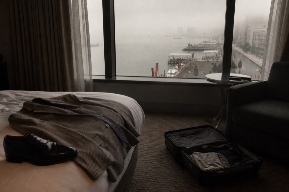 A sports coat and dress shoes laid out on a hotel bed before a dinner cruise