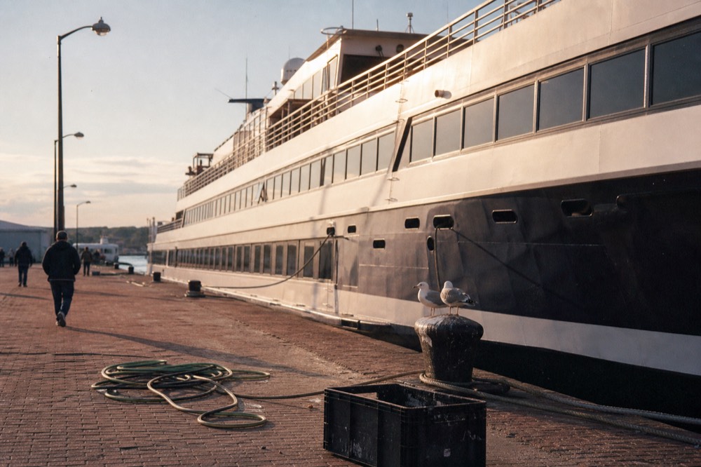 A cruise vessel docked at a Boston pier in early evening light