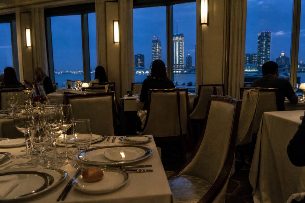 Dinner cruise tables set with harbor view at dusk