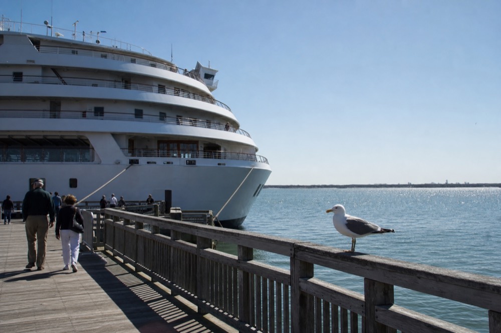 A multi-deck dinner cruise vessel docked at a Seaport pier in Boston