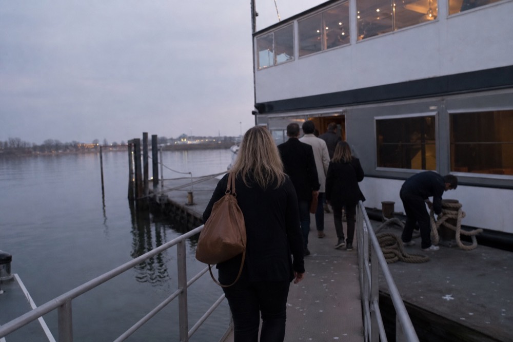 Passengers boarding a dinner cruise at dusk on a quiet weeknight